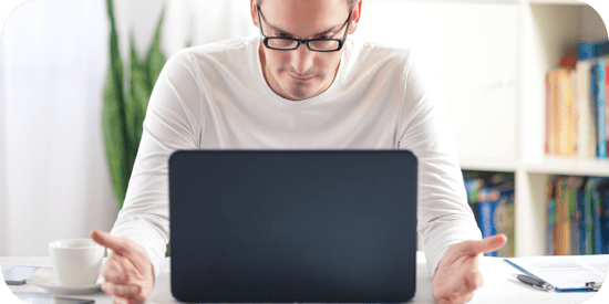 A marketer sitting at a desk, looking frustrated while reviewing something on a laptop — representing the risks of trusting AI-generated code without validation.